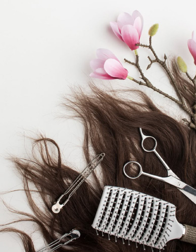 آرایشگر با ماسک و دستکش در حال ضدعفونی تجهیزات آرایشگاهی