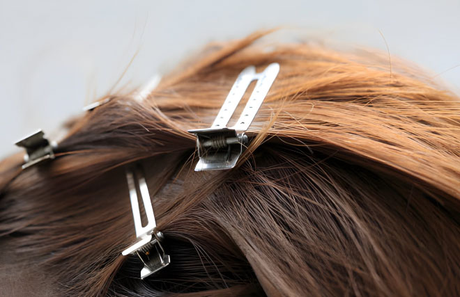 کلیپس فلزی آرایشگاهی در حال نگه داشتن بخش ضخیم مو