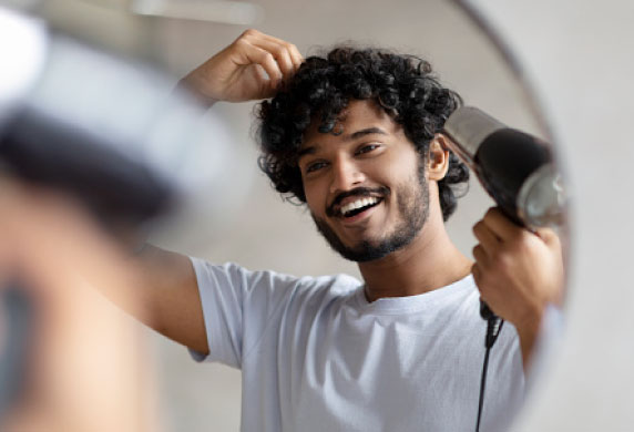 «سشوار یونی در حال خشک کردن موهای فر برای کاهش وز و حفظ رطوبت